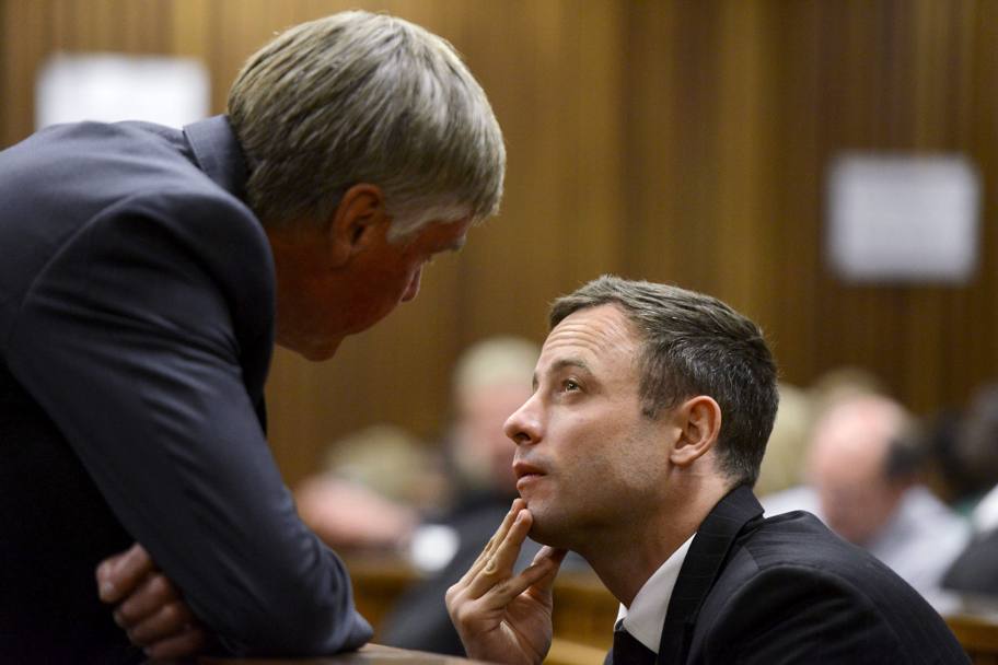 Oscar Pistorius parla a uno dei suoi avvocati prima della sentenza (Reuters)
